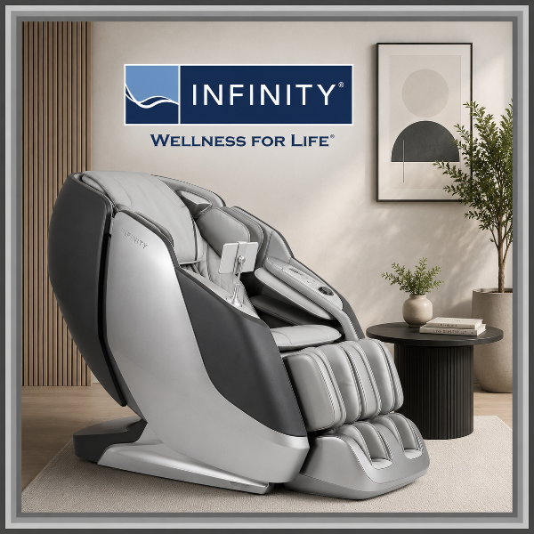 Infinity massage chair displayed in a modern minimalist room with neutral décor, gray accent frame, and Infinity Wellness for Life logo.