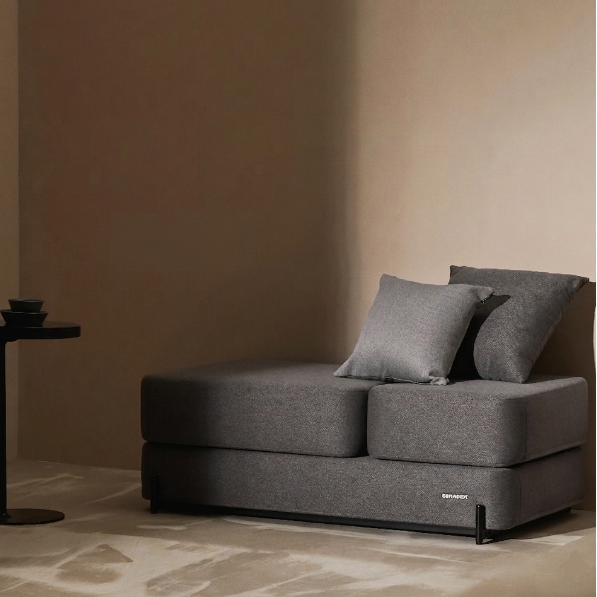 Gray Ceragem S4 massage bed with cushions in a minimalistic room with a side table.