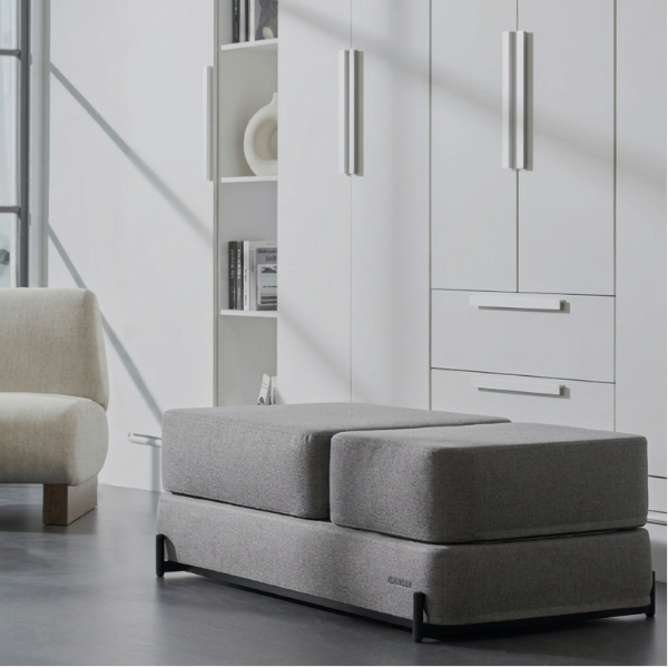 Modern living room with a gray Ceragem S4 Massage Lounger, armchair, and coffee table.
