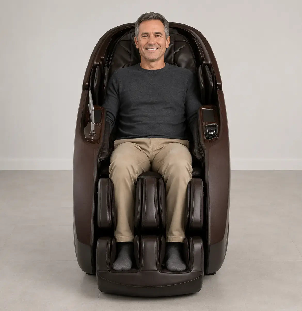 Middle-aged man seated in the chocolate Daiwa Supreme Hybrid massage chair in a contemporary room with gray flooring and white walls.