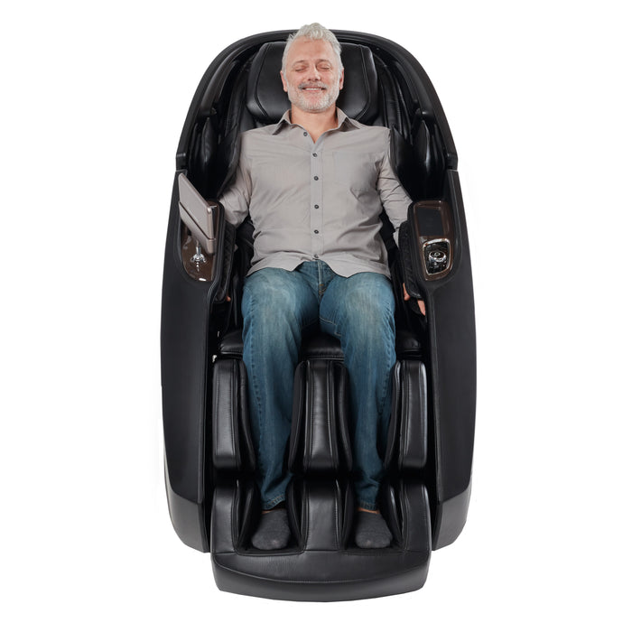 Front-facing view of a user in the black Daiwa Supreme Hybrid X, highlighting the specialized shoulder airbags and the expansive legrest assembly.