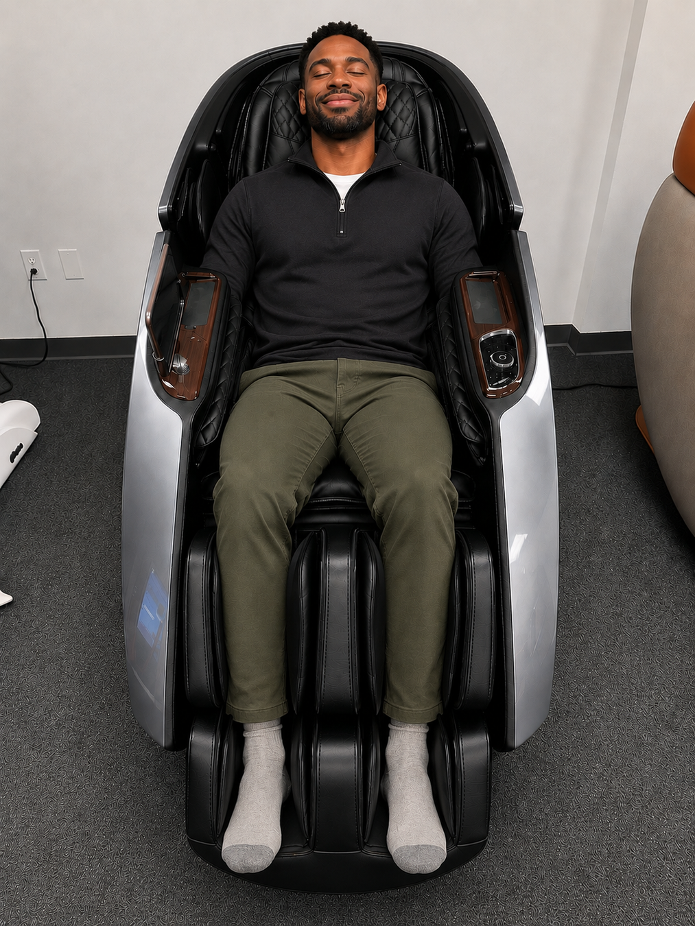 A man testing the premium grey Daiwa Supreme Hybrid X massage chair at the Houston, Texas luxury showroom of The Modern Back.