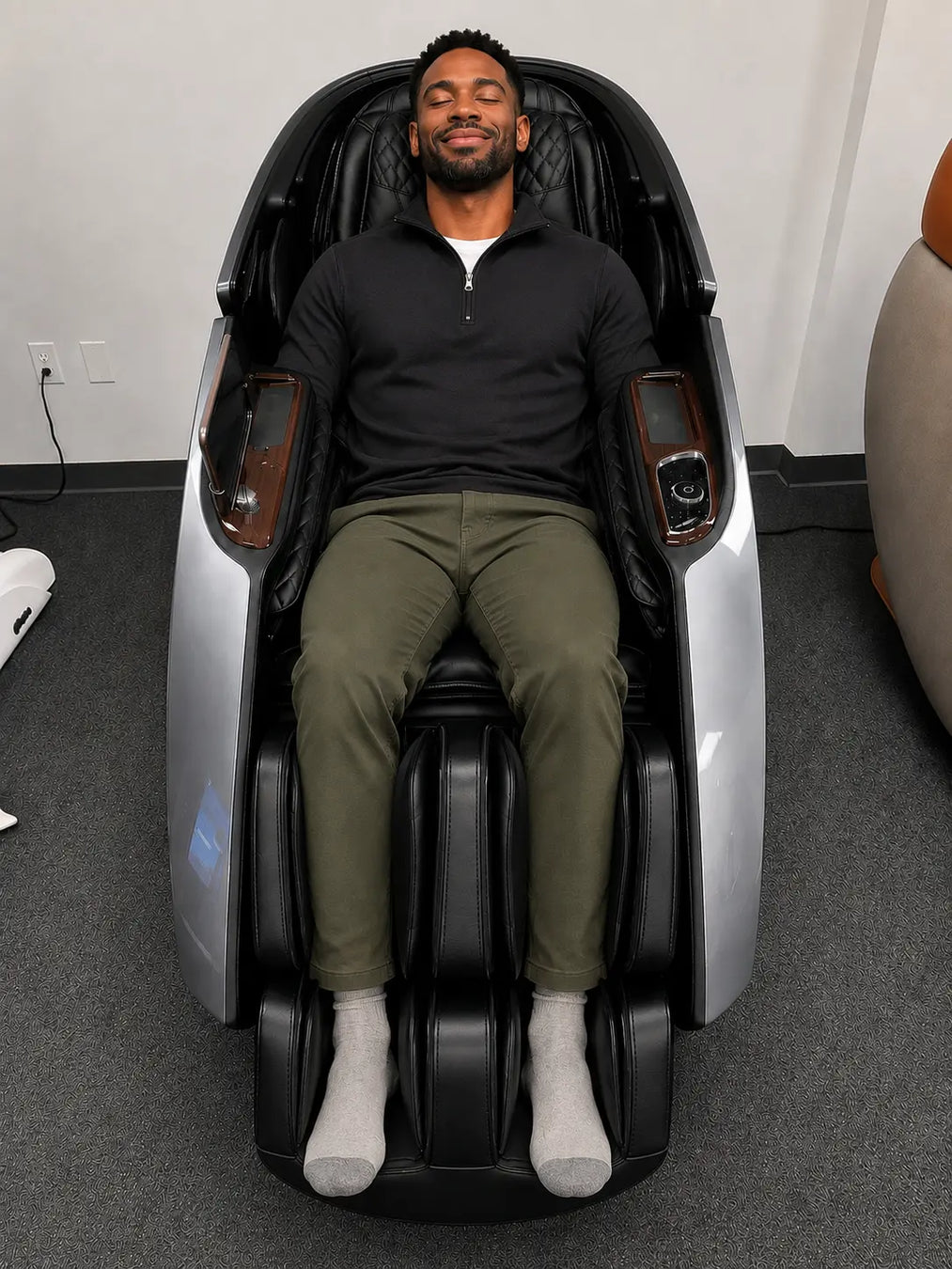A man testing the premium grey Daiwa Supreme Hybrid X massage chair at the Houston, Texas luxury showroom of The Modern Back.