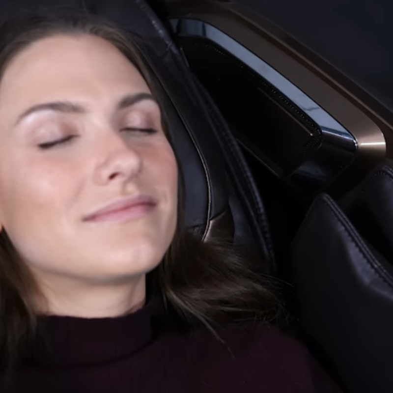 User reclining in massage chair using voice command function for hands-free operation.