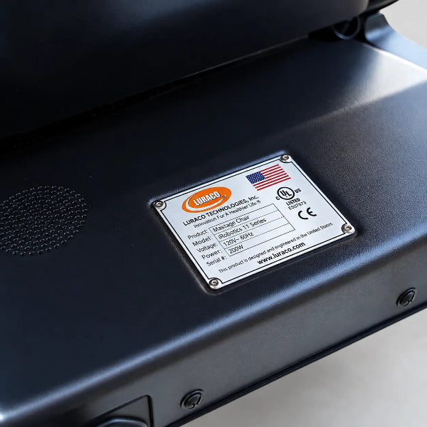 Close-up of the Luraco iRobotics i11 Special Edition Medical Massage Chair identification plate featuring the American flag, manufacturer details, and UL and CE certification markings.