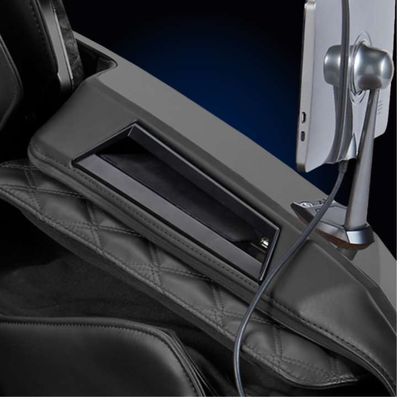 Armrest with built-in wireless phone charging pad and USB port for devices.
